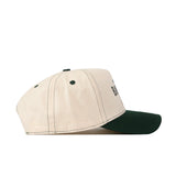 The Baylor Bears Vintage Hat by No Rivals is a beige baseball cap with a dark green brim, displayed from the side. It features two green eyelets, black stitching along the panels and brim, and is crafted from high-quality cotton. This snapback hat offers an adjustable design to ensure a comfortable fit for all sizes.
