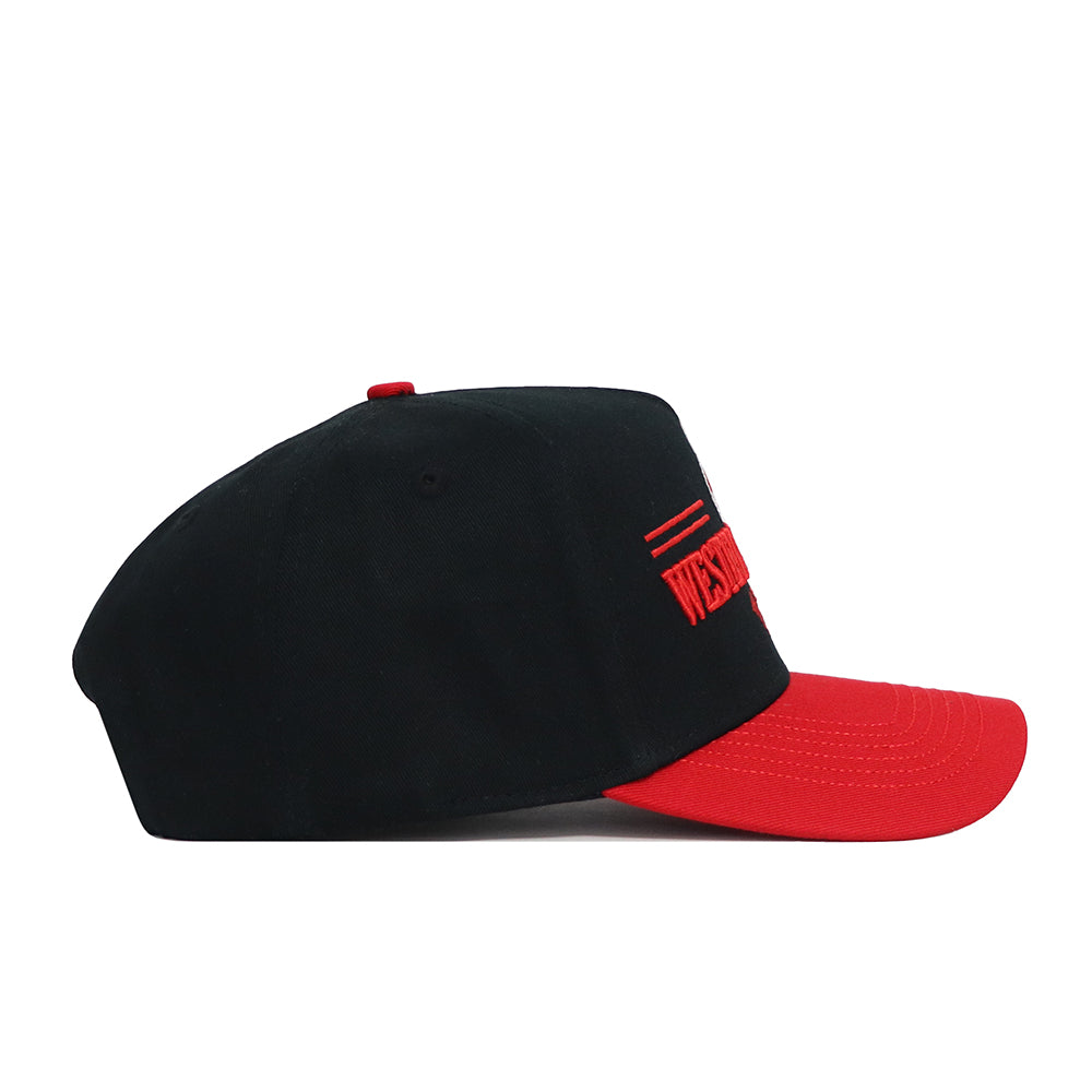 The No Rivals Western Kentucky Tailgate Hat is shown from the left side, featuring a black snapback design with a red brim, red button, embroidered red text and lines on the front panel, and a structured cotton fit.