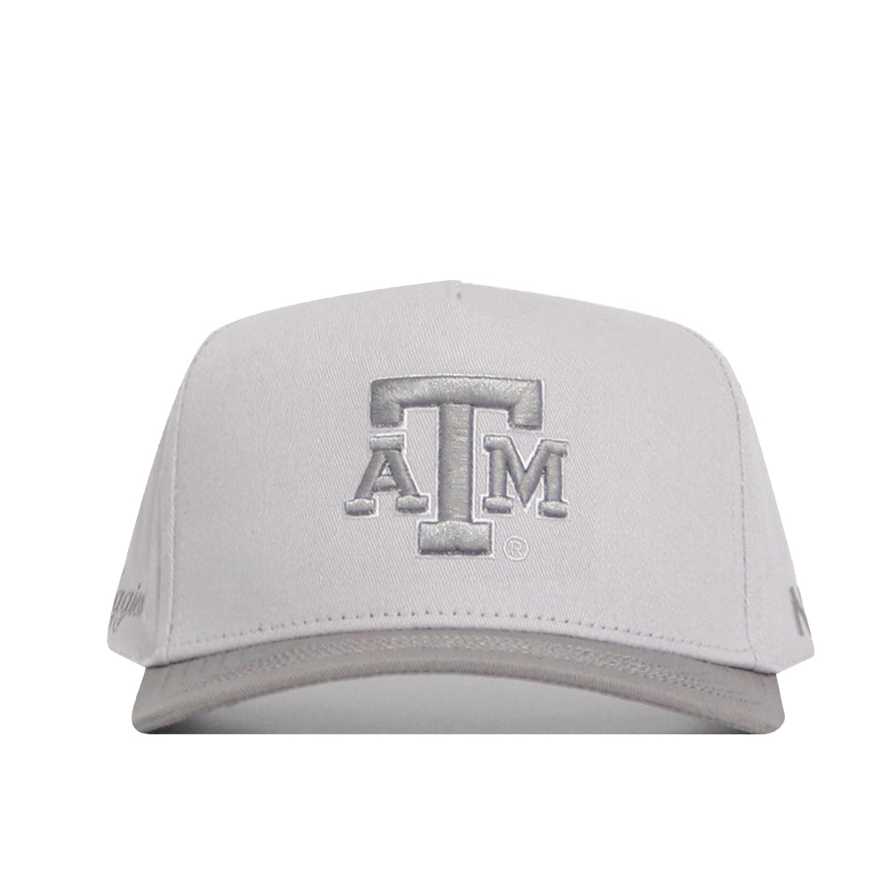 The No Rivals Texas A&M Graphite Hat is a light gray snapback with the ATM logo embroidered in silver on the front. Made of high-quality cotton, this structured-fit cap is pictured from the front against a white background.