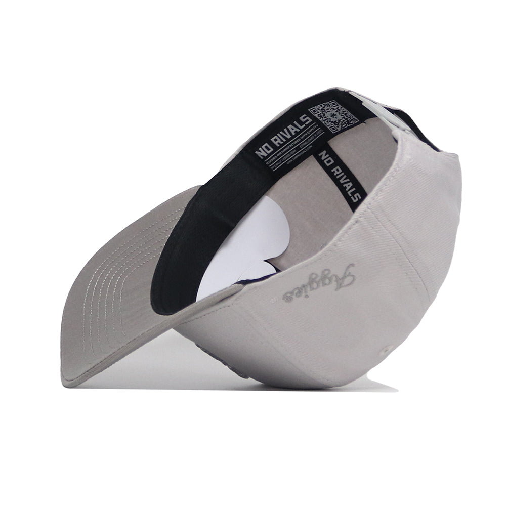 A Texas A&M Graphite Hat by No Rivals is shown flipped upside down, revealing a black-trimmed interior labeled NO RIVALS. "Aggies" is embroidered in gray on the outside of the brim.