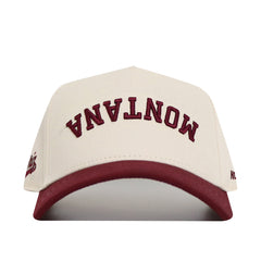 An upside down white and maroon MONTANA hat with an adjustable snapback closure.