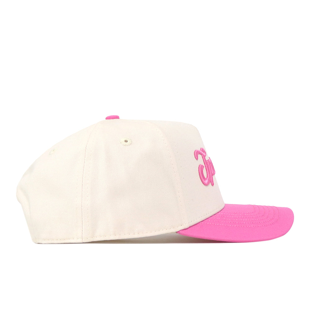 A cream-colored Michigan State Pink Out Hat by No Rivals, officially licensed and featuring a pink brim with pink embroidered lettering on the front, is shown from the side against a white background. This stylish snapback not only offers comfort but also serves as a breast cancer awareness hat, supporting an important cause.