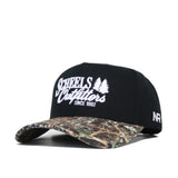 The Scheels Camo Trailblazer Hat is a black snapback with white embroidered text and two pine trees on the front, a camo-pattern brim, and a small white AF logo on the side. Made from high quality cotton with a structured fit.