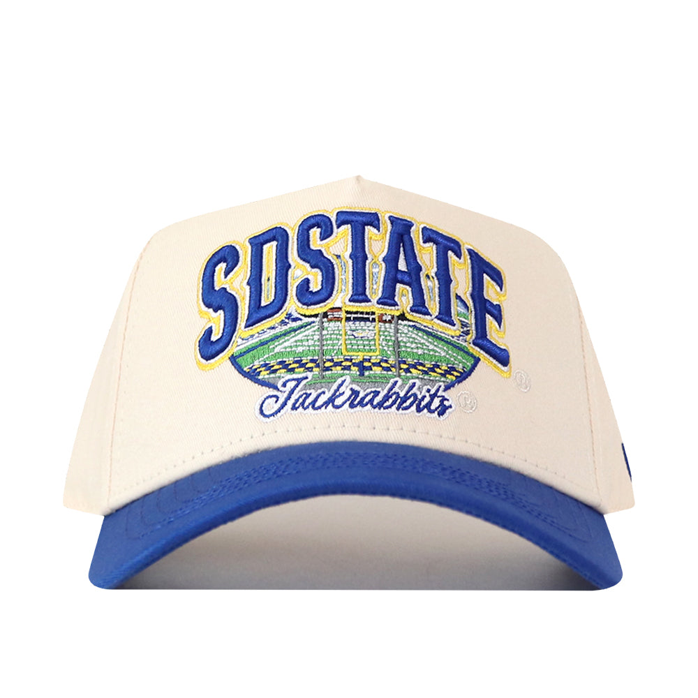 The No Rivals South Dakota State Jackrabbits Stadium Hat is a white snapback with a blue brim, featuring SDSTATE and Jackrabbits embroidered in blue and yellow alongside a detailed stadium illustration on the front—perfect for your gameday look and proudly displaying its bold embroidery.
