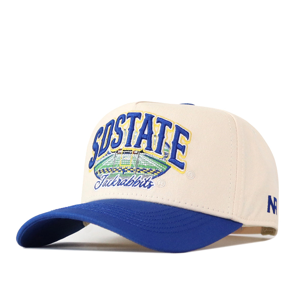 A cream and blue South Dakota State Jackrabbits Stadium Hat by No Rivals, this snapback features SDSTATE Jackrabbits embroidered on the front in blue and yellow letters. The hat has a blue brim and showcases detailed, officially licensed collegiate sports branding for an authentic look.