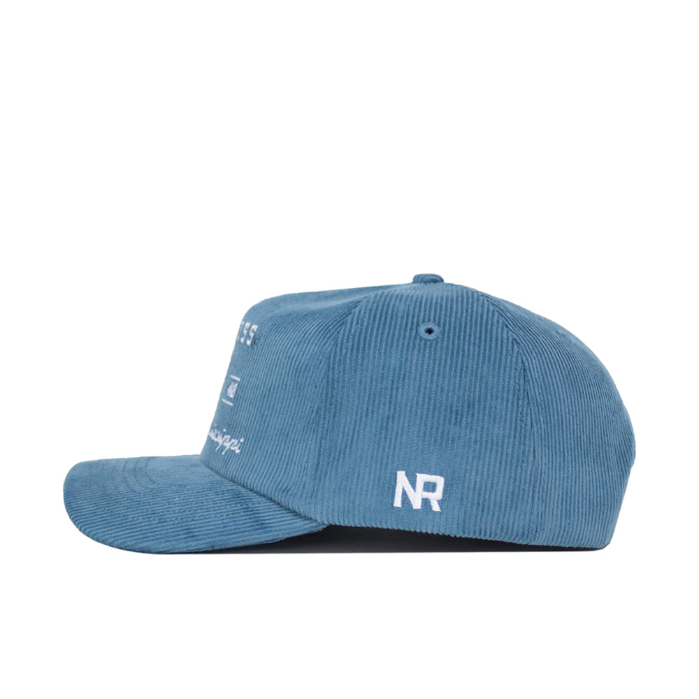 The Ole Miss Vintage Cord Hat by No Rivals is shown from the side in powder blue corduroy, featuring an unstructured fit and white embroidered details, including "NR" initials above the brim.