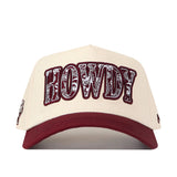 The No Rivals Texas A&M Paisley Howdy Hat is a cream-colored snapback cap with a maroon bill, showcasing “HOWDY” in bold, patterned maroon and white letters on the front. This officially licensed hat features an embroidered logo for a stylish and authentic finish.