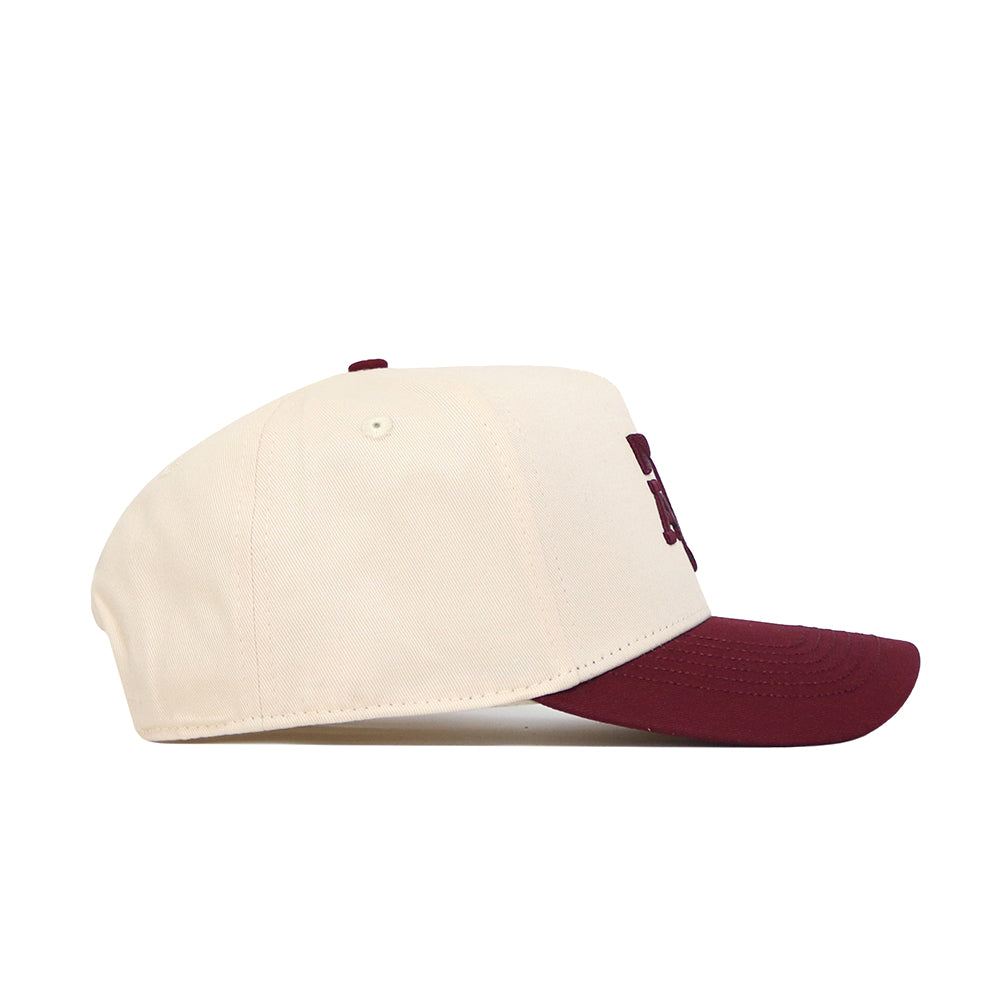 The No Rivals Texas A&M Logo Patch Hat features a cream crown, maroon brim, and 3D embroidery, crafted from premium cotton. Shown in side profile against a white background.