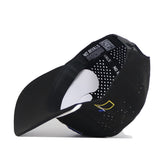 A black South Dakota State Golf Hat by No Rivals is shown from underneath, revealing the interior band with “NO RIVALS” text and a QR code, along with a partial view of the officially licensed embroidered yellow and blue logo.