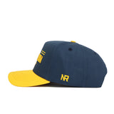 The No Rivals West Virginia Tailgate Hat is a navy cotton snapback with a yellow curved brim, yellow embroidered NR on the side, and a structured fit, shown in side profile against a white background.
