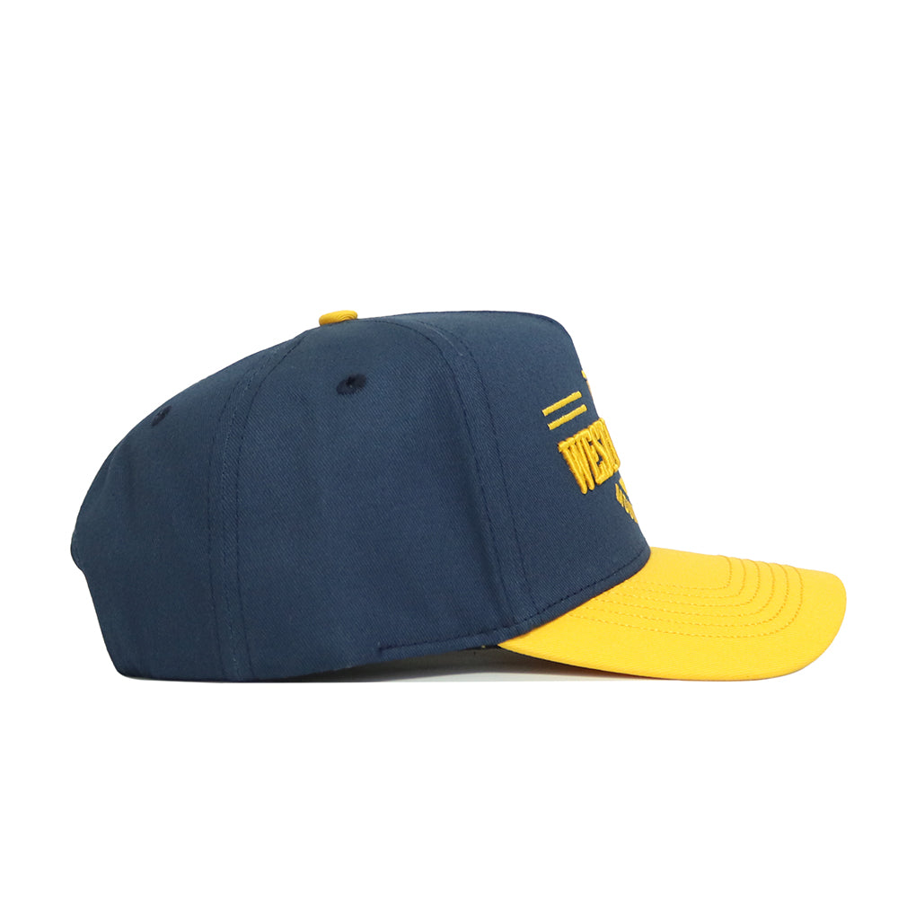 The No Rivals West Virginia Tailgate Hat is a navy snapback with a yellow curved brim and embroidered front text, made from structured cotton fabric, shown in a side view against a white background.