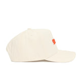 The Clemson Sideline Hat by No Rivals is a beige cotton baseball cap with a curved brim, structured fit, and small orange embroidered logo on the front, shown from the side against a plain white background.