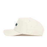 Side view of the Michigan State Sideline Hat by No Rivals, an off-white snapback in premium cotton with a structured fit, subtle NR embroidery on the side, and partially visible green text on the front.