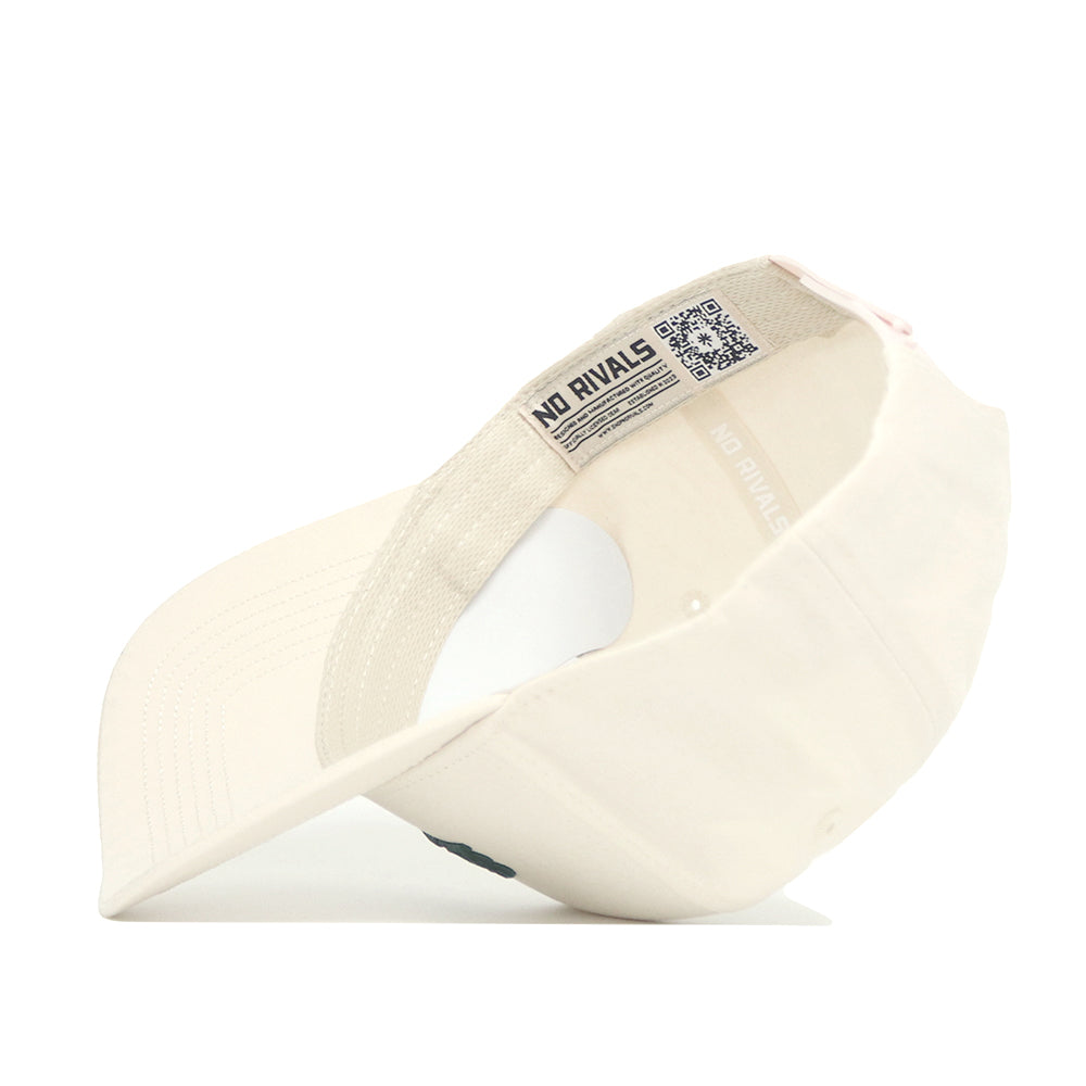 The Michigan State Sideline Hat by No Rivals is pictured upside down, showing its cream color, structured fit, interior label with "NO RIVALS" and QR code, plus the underside of the brim and cap's interior.