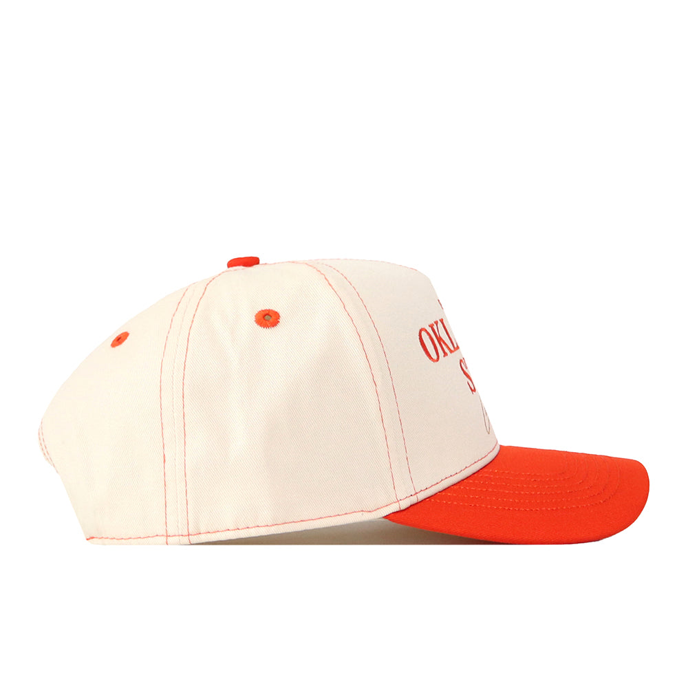 Elevate your gameday fit with the Oklahoma State Cowboys Vintage Hat by No Rivals—a cream-colored team cap featuring an orange brim, orange stitching, orange top button, and partially visible orange embroidered text on the front panel.