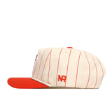 The Bowling Green State Falcons Pinstripe Hat by No Rivals features cream cotton fabric with thin red pinstripes, a bold red flat brim, and “NR” embroidered in red on the side. Designed for comfort and style, it includes a durable snap back closure for an adjustable fit.