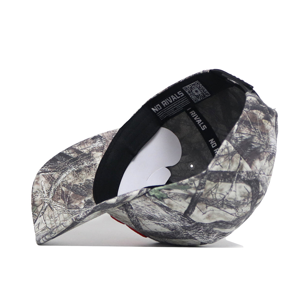 The Syracuse Outland Hat by No Rivals, a high-quality cotton snapback with a camouflage pattern, is shown on its side to display the inner band’s NO RIVALS label and a white sticker on the brim.