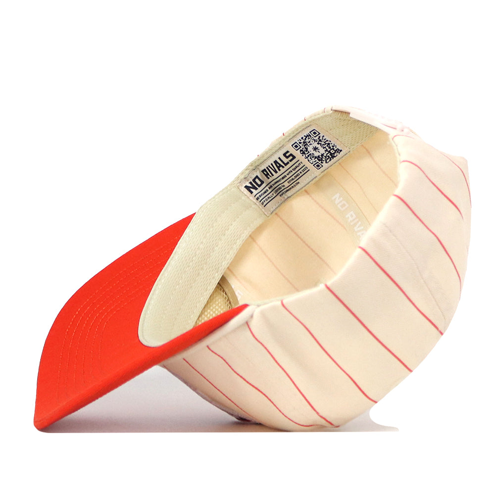 The Bowling Green State Falcons Pinstripe Hat by No Rivals is displayed upside down, revealing its bright red brim and an interior label with text and a QR code. Made from high-quality cotton in a cream color with thin red stripes, this hat also includes a convenient snap back adjustment for a comfortable fit.