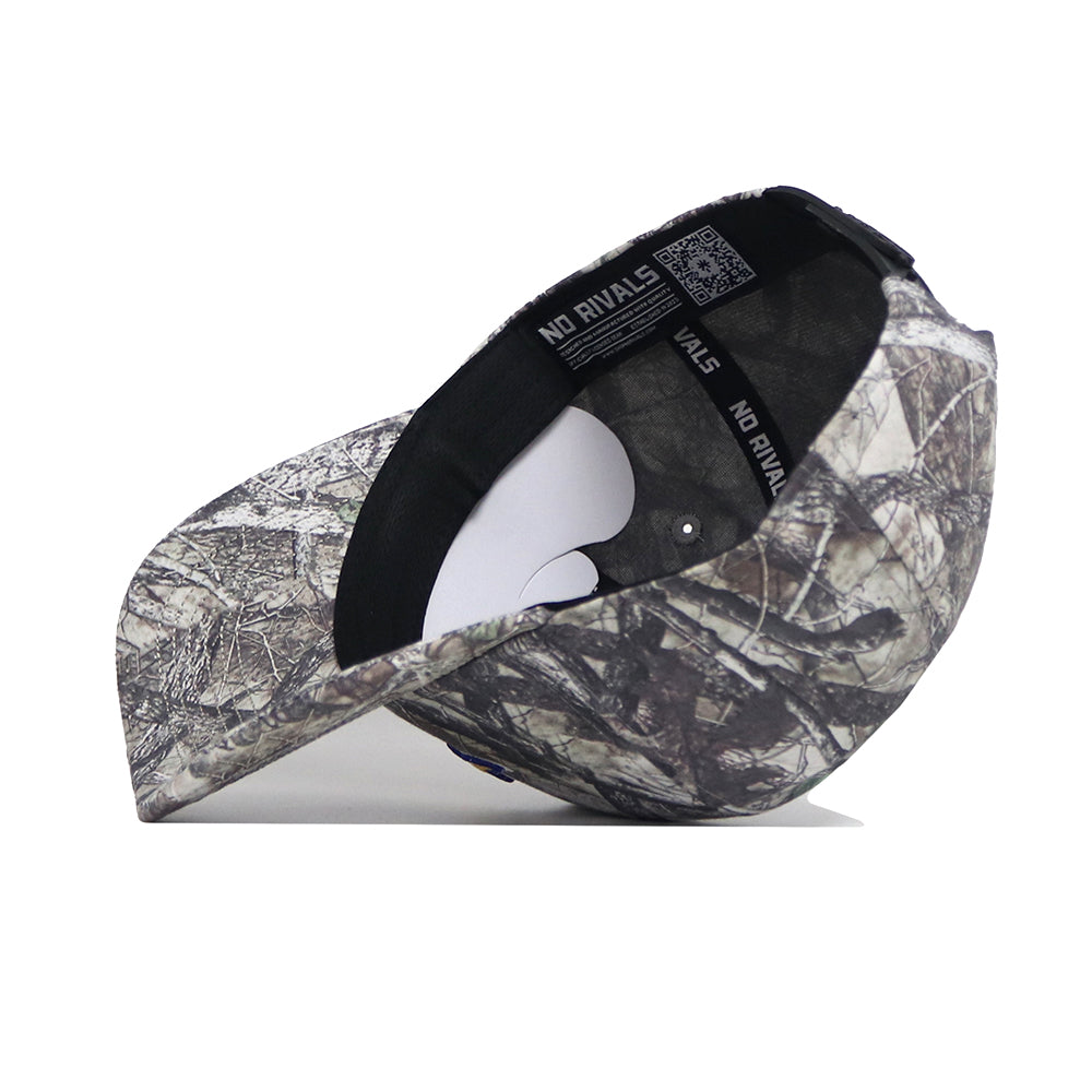 The South Dakota State Outland Hat by No Rivals is displayed upside down, showing its camouflage pattern, structured fit, inner lining, sweatband with "NO RIVALS" text, and a white paper insert beneath the crown.