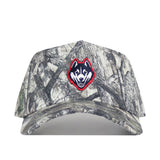 The UConn Outland Hat by No Rivals is a camo baseball cap with an embroidered husky logo outlined in red on the front, made from high-quality cotton and designed with a snapback for adjustable fit.