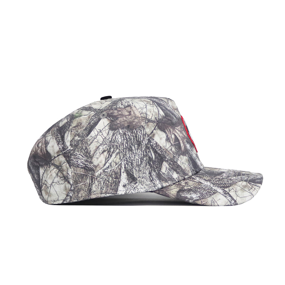 A side view of the No Rivals UConn Outland Hat in gray and brown camo, made of high-quality cotton with a structured fit, slightly curved brim, and a subtle red accent on the front.