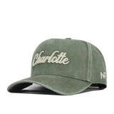 Introducing the Charlotte Home Turf Hat by No Rivals: a green snapback cap featuring “Charlotte” embroidered in white script across the front and “NF” stitched on the side. This hat boasts a curved brim, a soft suede-like texture, and classic embroidered logos—perfect for showing your team spirit on gameday.