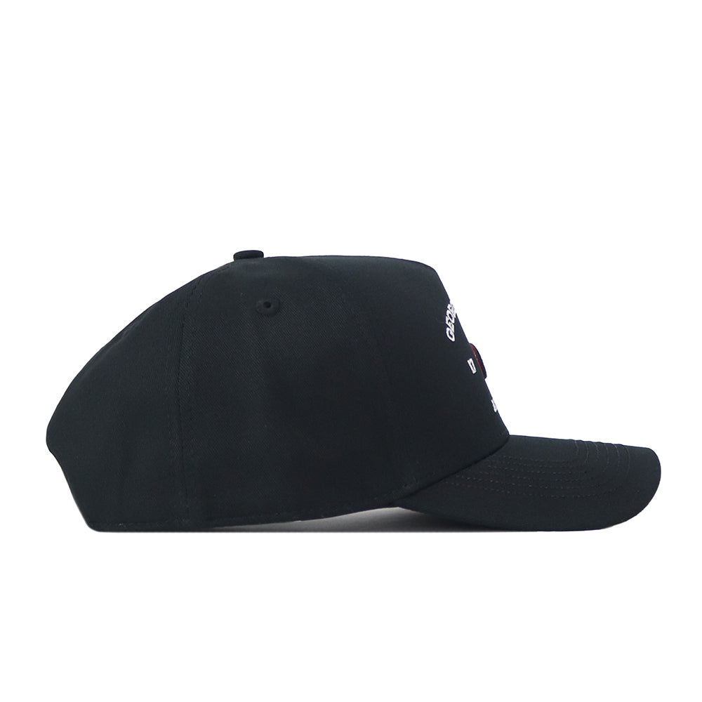 The Georgia Outlaw Hat - Black by No Rivals is displayed from the side against a white background. This black cap features a curved brim and a partially visible small white embroidered logo on the front, making it perfect for finishing your gameday look. It also offers a convenient snap back adjustment for a customizable fit.
