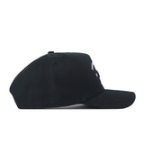 The Georgia Outlaw Hat - Black by No Rivals is displayed from the side against a white background. This black cap features a curved brim and a partially visible small white embroidered logo on the front, making it perfect for finishing your gameday look. It also offers a convenient snap back adjustment for a customizable fit.