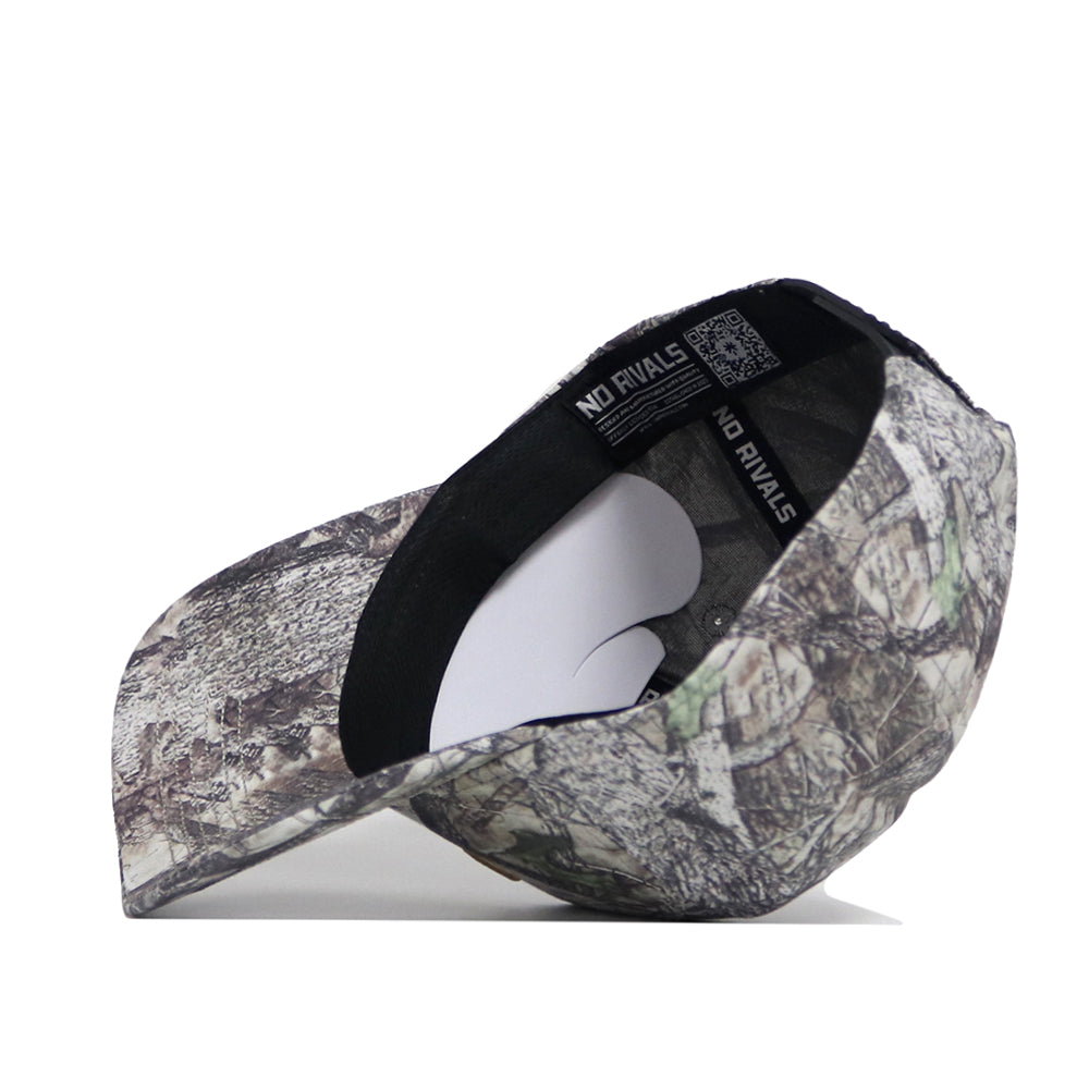 The No Rivals Colorado Outland Hat, a high-quality cotton baseball cap with a camouflage pattern, is shown from the side and above. Its structured fit displays the interior and black inner band, with the brim facing left.