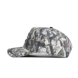 The No Rivals ETSU Outland Camo Hat features a side view of its camouflage pattern, a curved brim, embroidered white NB logo near the back, and a structured fit for added style.
