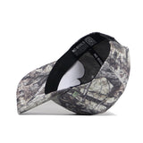 The Kansas Outland Hat by No Rivals is a structured-fit camouflage baseball cap made of high-quality cotton, featuring a curved brim, inner black band, and white NO RIVALS tag. Its woodland-inspired pattern stands out with premium craftsmanship.