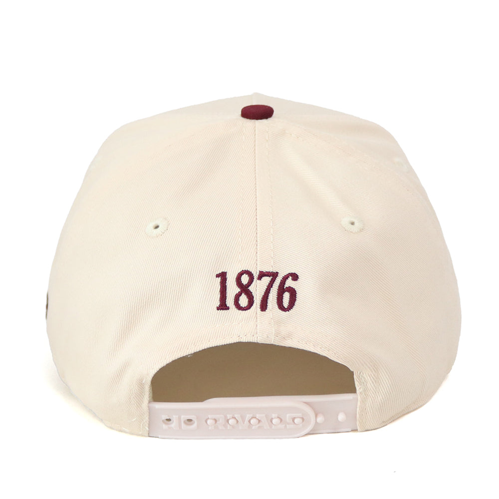 A white snap back Texas A&M Star Hat by No Rivals is shown from the back, featuring “1876” embroidered in maroon above the adjustable strap, along with an officially licensed embroidered logo.