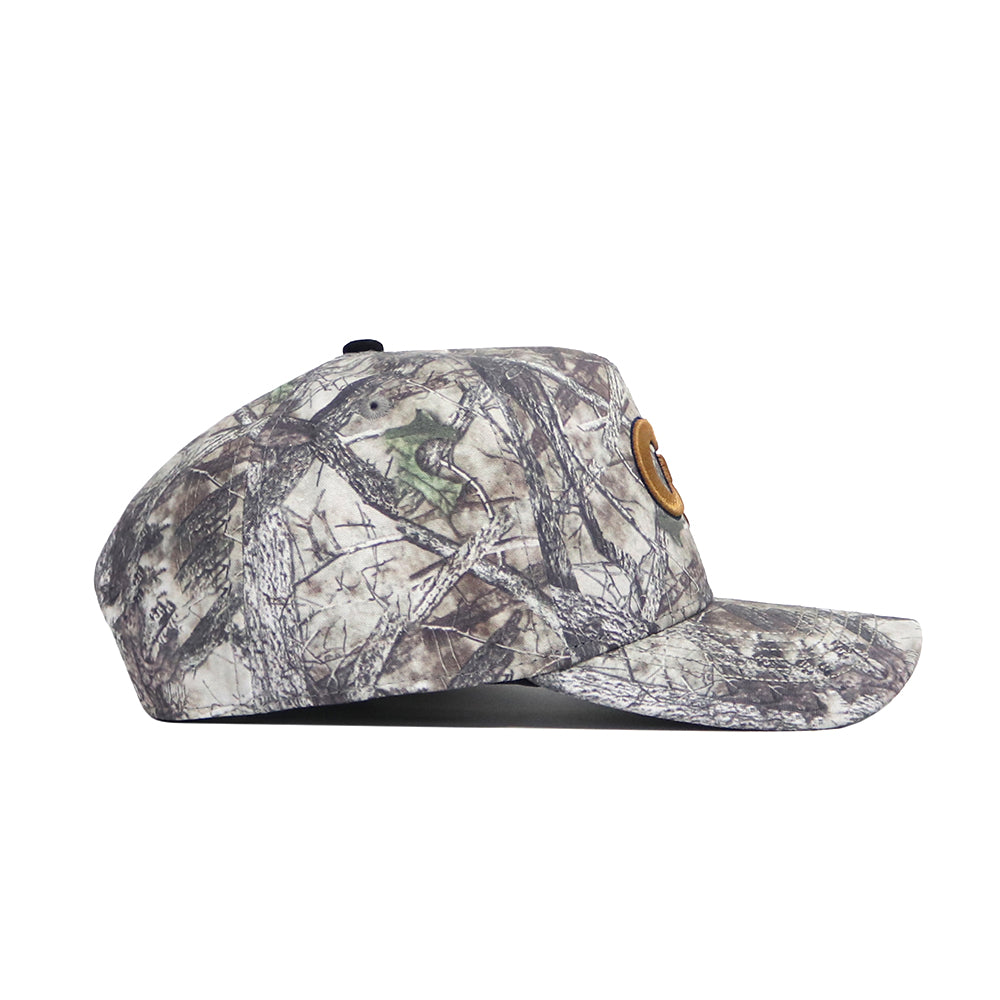 The Georgia Tech Outland Hat by No Rivals is a structured fit snapback with a flat brim, brown patch on the front, and features a woodland camo pattern with branch and leaf designs.