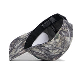 The North Texas Outland Hat by No Rivals is a high-quality cotton snapback with a green, brown, and gray camouflage pattern. Pictured on its side with the brim left, it features an inside label reading NO RIVALS.