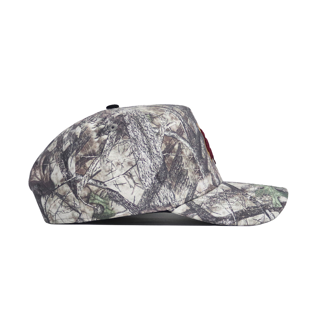 Side view of the No Rivals Texas State Outland Hat, a structured flat-brim cap with a forest camouflage pattern of branches and leaves, crafted from high-quality cotton and shown against a white background.