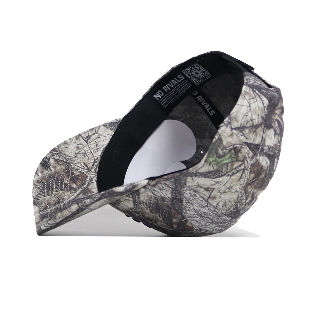 The Texas State Outland Hat by No Rivals is shown upside down, revealing its black inner band with "NO RIVALS" printed in white. This camo-patterned snapback baseball cap is crafted from high-quality cotton and has a structured fit against a white background.