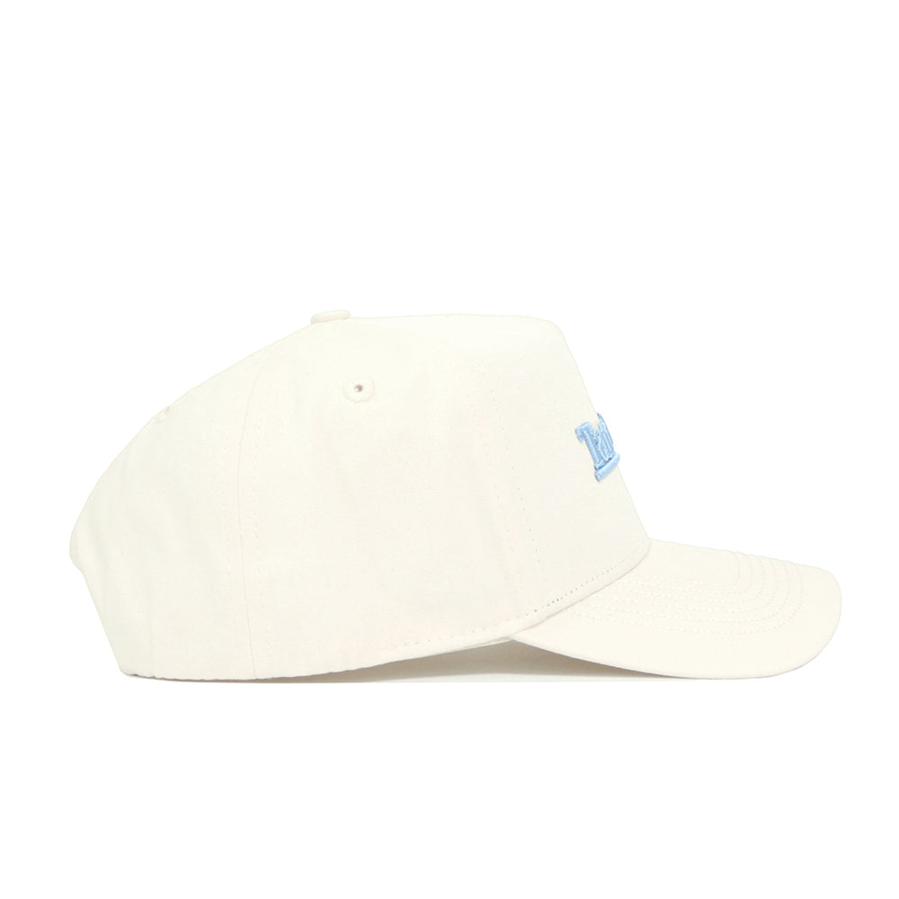The North Carolina Sideline Hat by No Rivals is a cream-colored, high-quality cotton cap with small ventilation holes, a structured fit, and light blue "North Carolina" text embroidered on the front.