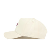 The No Rivals Florida State Sideline Hat is a cream-colored, structured cotton baseball cap. Seen from the side, it has subtle stitching on the brim and minimal embroidery, including a small white logo near the back.