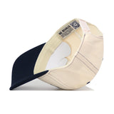 A beige and navy blue Toledo Rockets Vintage Hat by No Rivals is shown inside out, highlighting the NO RIVALS label and detailed inner stitching. This officially licensed snapback features an embroidered logo for added style.