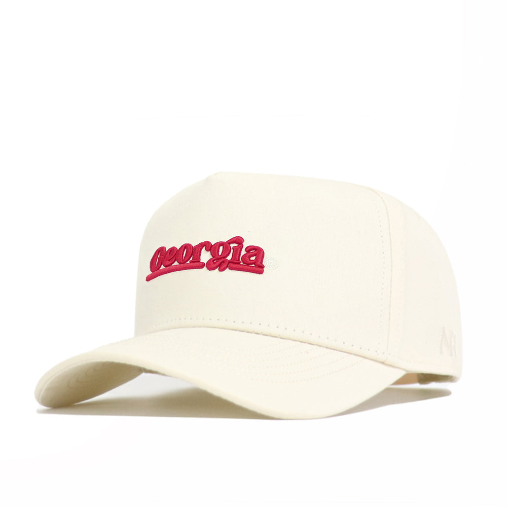 The Georgia Sideline Hat by No Rivals is a cream-colored snapback made from premium cotton, with "georgia" embroidered in red cursive on the front. The cap is displayed on a white surface.