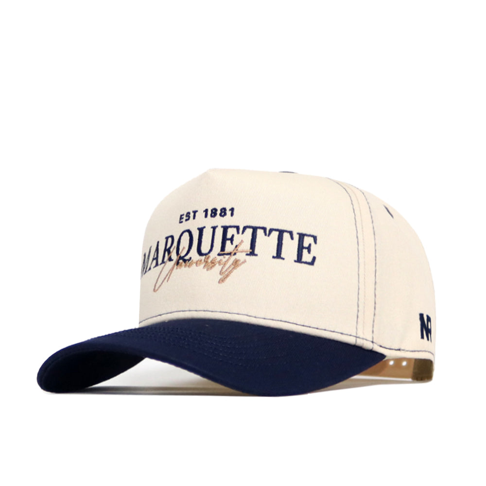 The No Rivals Marquette Vintage Hat is a cream and navy snapback with "EST 1881 Marquette University" embroidered on the front, a structured fit, navy brim, small NF logo on the side, and made from high-quality cotton.