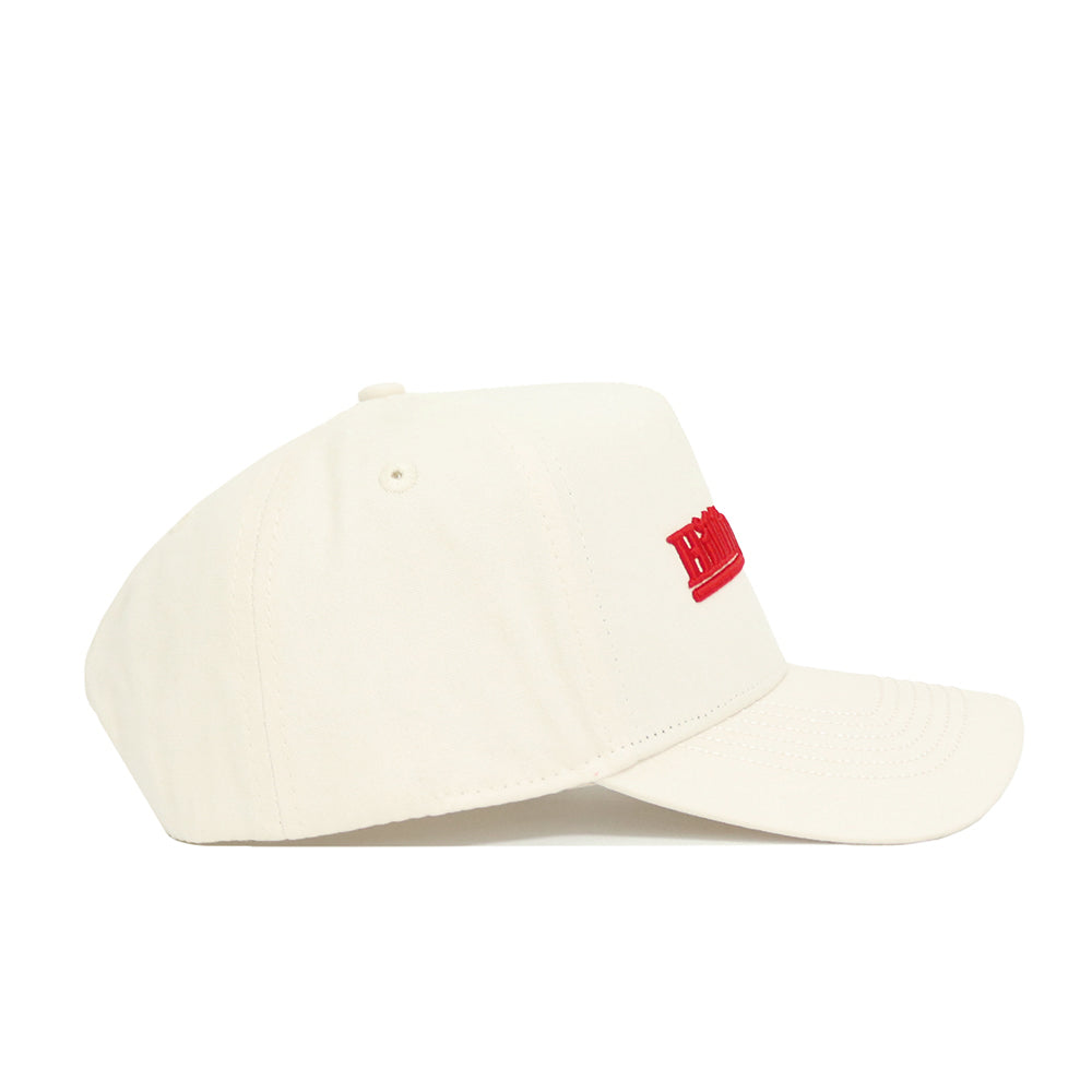 A side view of the No Rivals Western Kentucky Sideline Hat in off-white, featuring a curved brim and red front embroidery. Made from high-quality cotton, this cap offers a simple, clean design and soft feel.