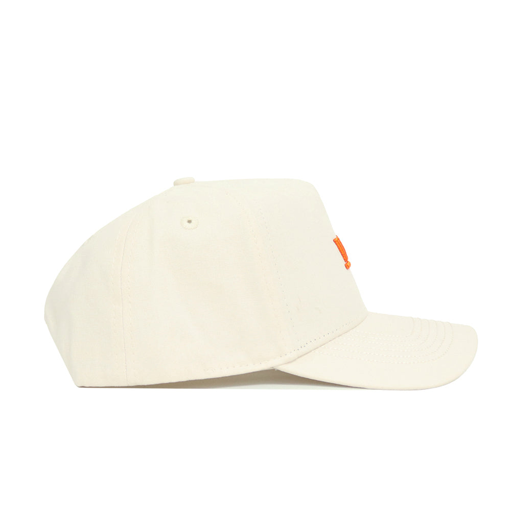The Tennessee Sideline Hat by No Rivals is a structured, off-white baseball cap with a small orange stitched detail on the front panel, shown from the side.