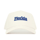 The No Rivals Florida Sideline Hat is a white cotton baseball cap with "Florida" embroidered in blue on the front and offers a structured fit.