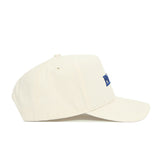 The No Rivals Florida Sideline Hat is a cream-colored, structured cotton baseball cap with a curved brim, small blue front embroidery, stitched eyelets, and a top button. Shown in profile.
