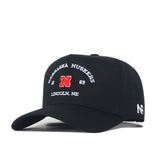 The Nebraska Outlaw Hat - Black by No Rivals is a black snapback featuring Nebraska Huskers and Lincoln, NE embroidered in white, a bold red “N” logo and “1869” on the front. The side showcases white “NR” initials, making it the perfect gameday fit for any fan.