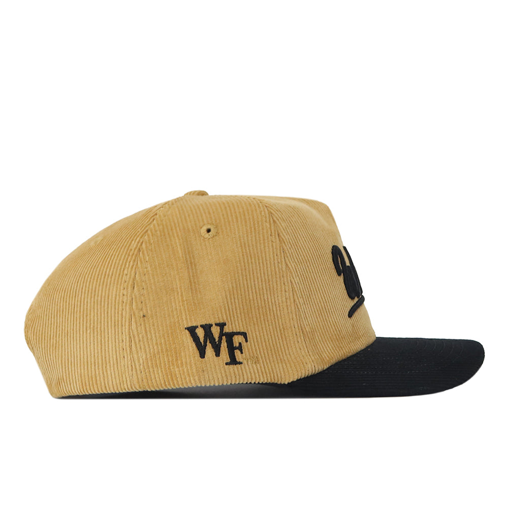 Introducing the No Rivals Wake Forest 2 Tone Gold Rush Hat—a tan corduroy cap with a black brim and bold, black embroidered WF letters on the side. This unstructured fit hat offers classic style and comfort with its adjustable snapback closure.