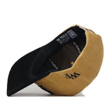 The Wake Forest 2 Tone Gold Rush Hat by No Rivals is displayed upside down, highlighting its unstructured fit, black interior, QR code label, and the NO RIVALS branding printed inside.