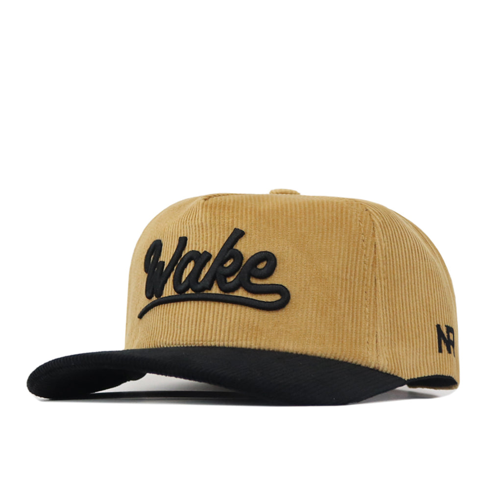 A tan corduroy Wake Forest 2 Tone Gold Rush Hat by No Rivals, this unstructured snapback features a black brim, “Wake” embroidered in black on the front, and a small black logo on the left side.