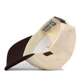 The Wichita State Espresso Hat by No Rivals is shown upside down, revealing the inner label, stitching, underbrim, and a QR code near the opening. Made from high-quality cotton.
